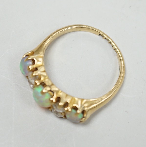 A late Victorian 18ct gold, three stone white opal and four stone diamond set half hoop ring, size M, gross weight 4.2 grams.